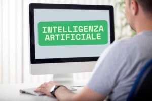 uomo guarda video al pc, scritta inteligenza artificiale