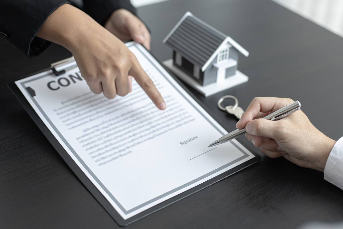 Uomo che firma il contratto di un mutuo