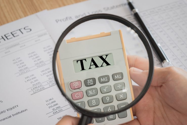 Lente d'ingrandimento su calcolatrice con scritta "TAX"