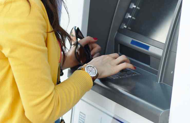 donna digita PIN ATM