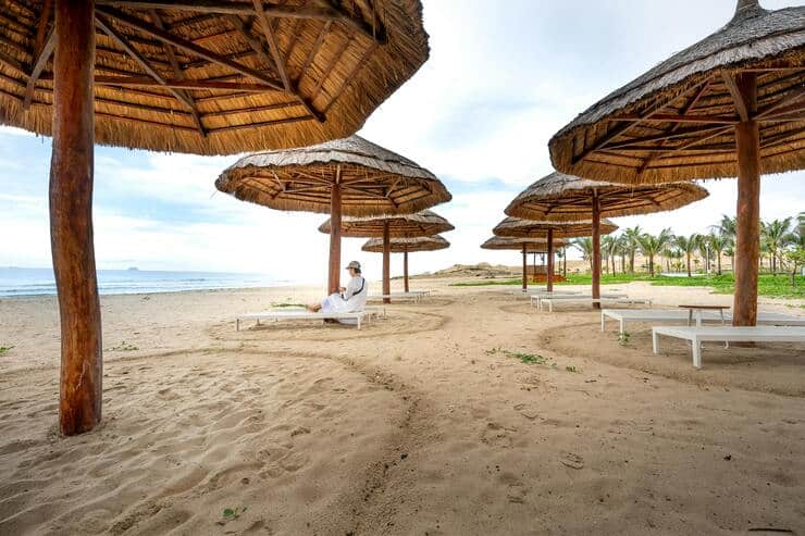 Spiaggia con ombrelloni con una sola persona seduta