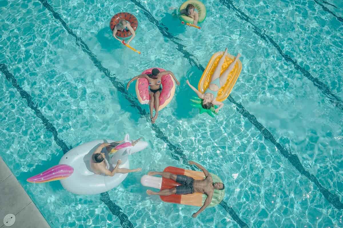Persone in piscina viste dall'alto, distese su dei gonfiabili