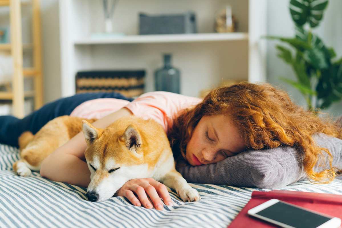 Ragazza che dorme di giorno vicino al suo cane