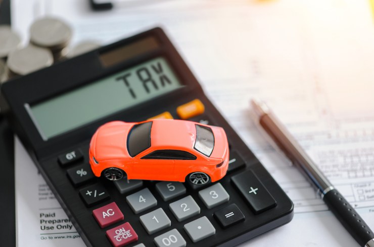 auto in miniatura sopra a calcolatrice con scritto "TAX"