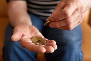 Inquadratura mani pensionato che conta le monete euro