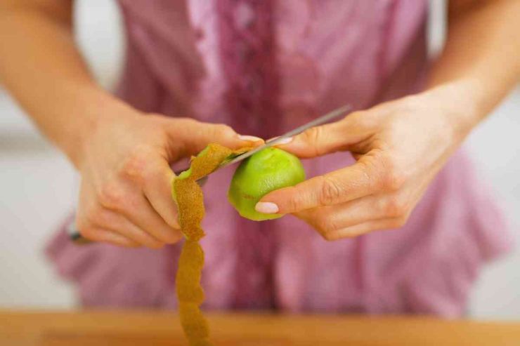 donna sbuccia kiwi