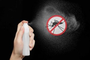 Boccetta spray che spruzza un repellente naturale e adesivo con la zanzara dentro un cartello di divieto