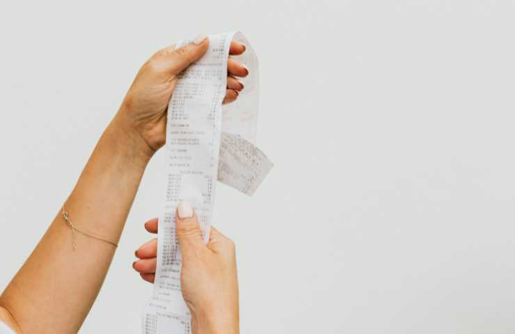 persona controlla scontrino spesa