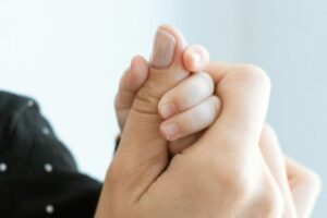 Mano di un neonato nella mano della madre