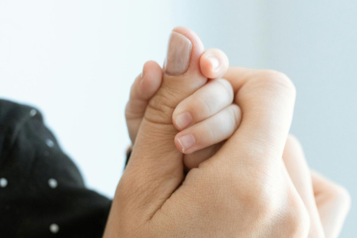 Mano di un neonato nella mano della madre