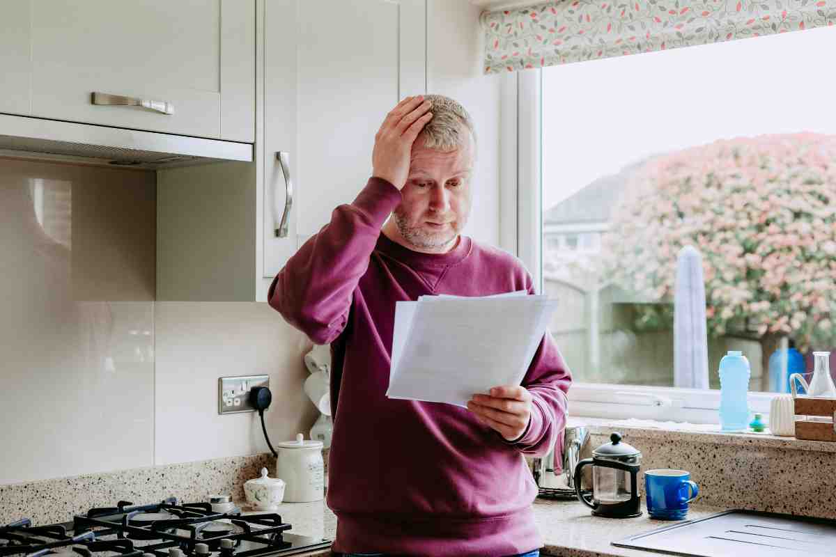 uomo esterrefatto legge documento