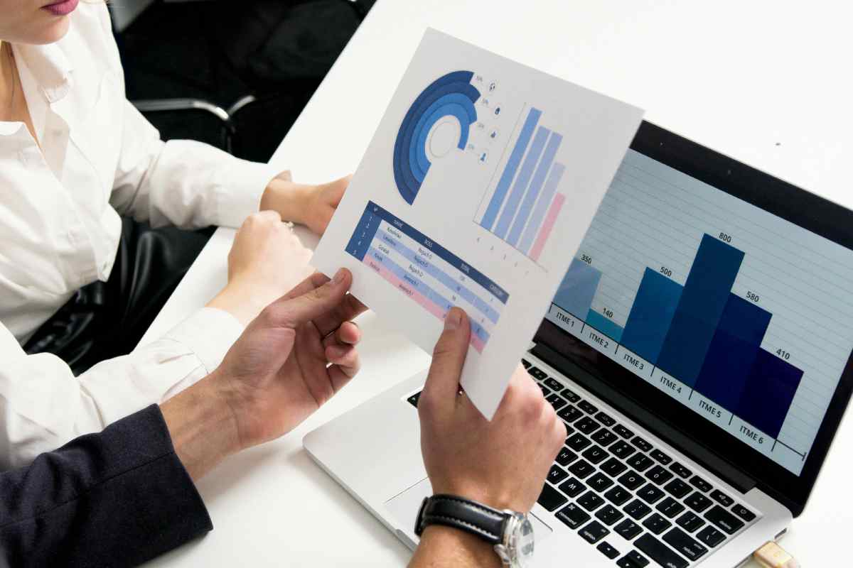Due persone di fronte a un portatile che analizzano un grafico con entrate in rosso