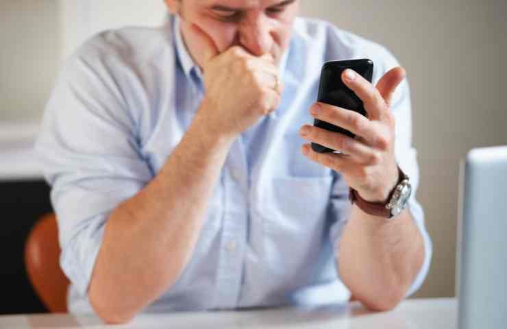 uomo preoccupato legge su cellulare