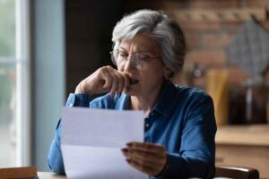 donna preoccupata legge documento