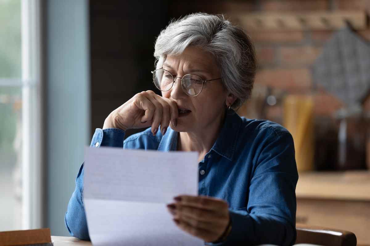 donna preoccupata legge documento