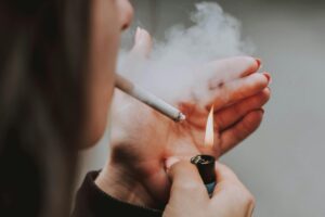 Una ragazza che si accende una sigaretta
