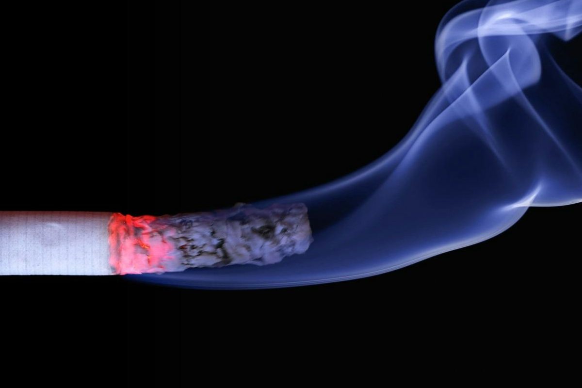 Una sigaretta acceea con cenere e fumo